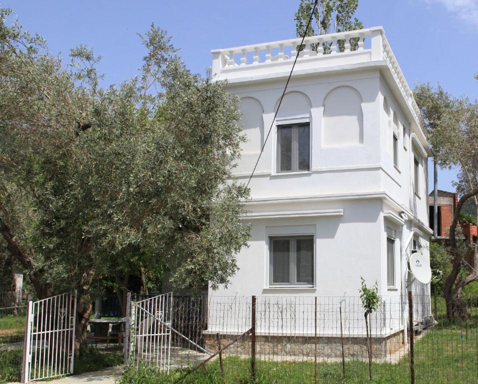 帕诺尔莫斯斯科派洛斯O Pyrgos Accommodations的前面有栅栏的白色房子