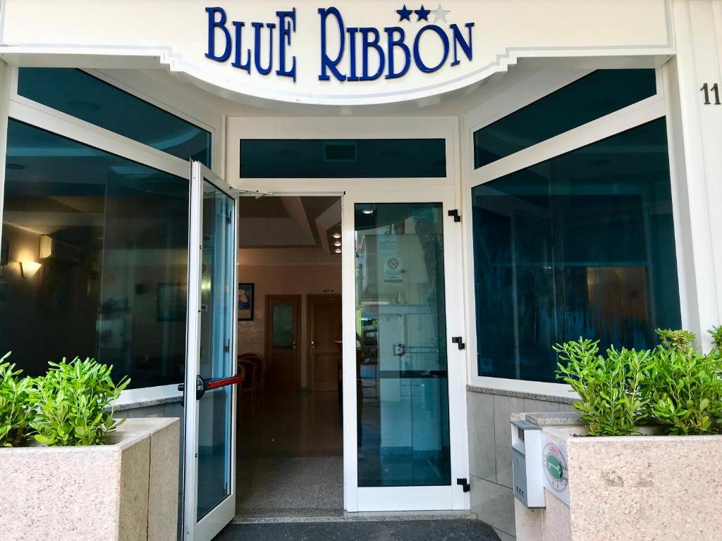 里米尼Hotel Blue Ribbon的门上方有蓝色带状标志的建筑