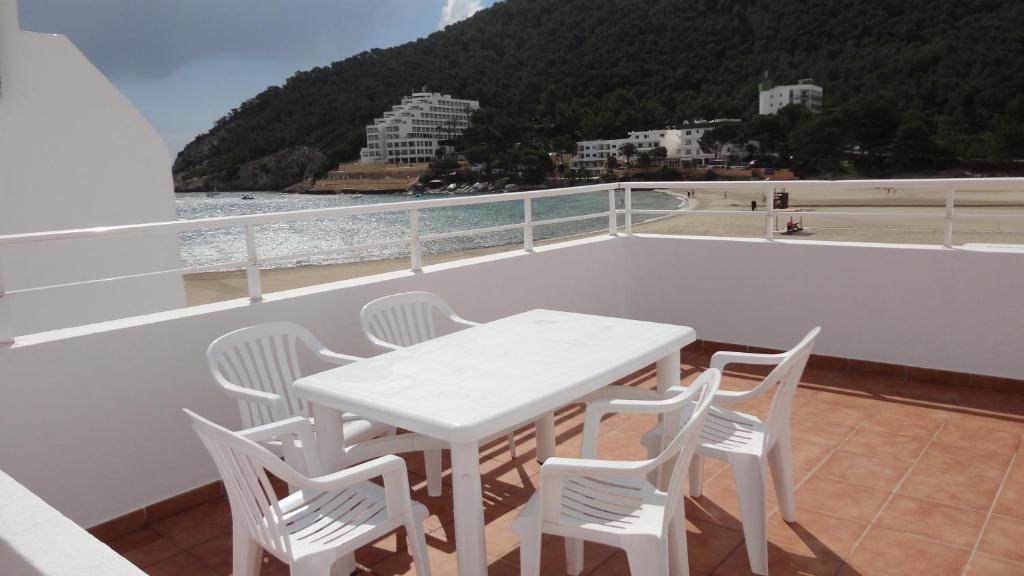 卡拉隆加卡拉浪噶公寓酒店的阳台上配有白色的桌椅,享有海景