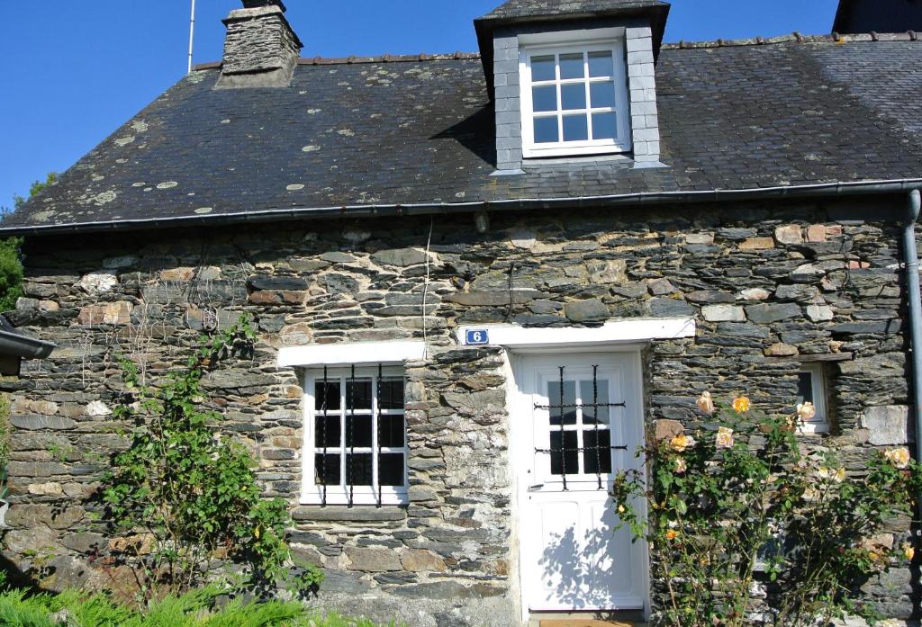 CaurelCaurel Cottage的一座古老的石头房子,设有白色的门窗