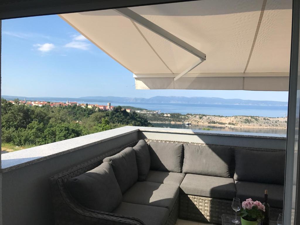 奥米沙利Apartmenthaus Suskovic Insel Krk的海景阳台上的沙发