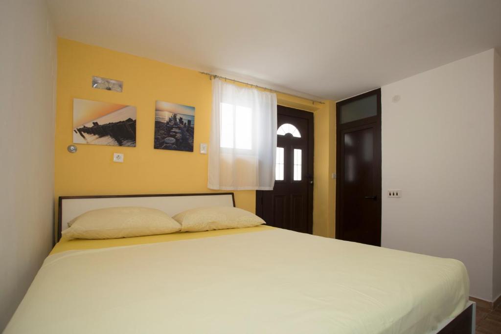 斯普利特Room Dioklecijan的卧室设有一张白色大床和黄色的墙壁