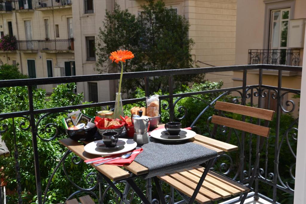 那不勒斯Casa Arcoiris的阳台上的桌子上摆放着食物和饮料