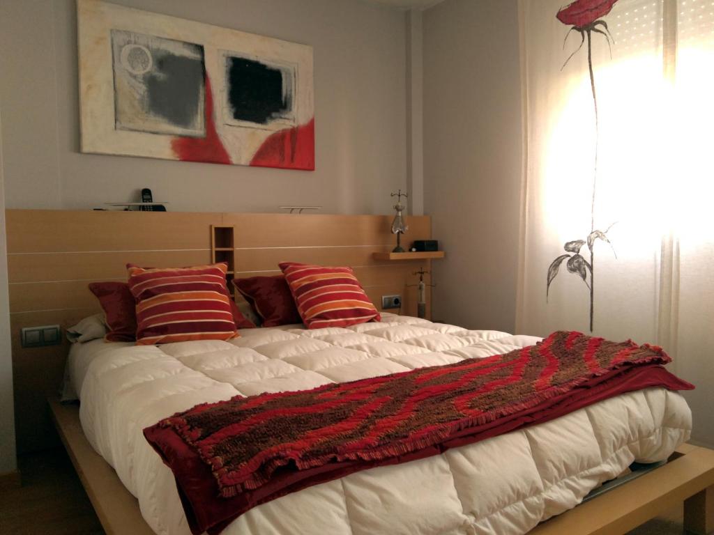 MurchanteLa casa de Marta的一间卧室配有一张带红色枕头的大床