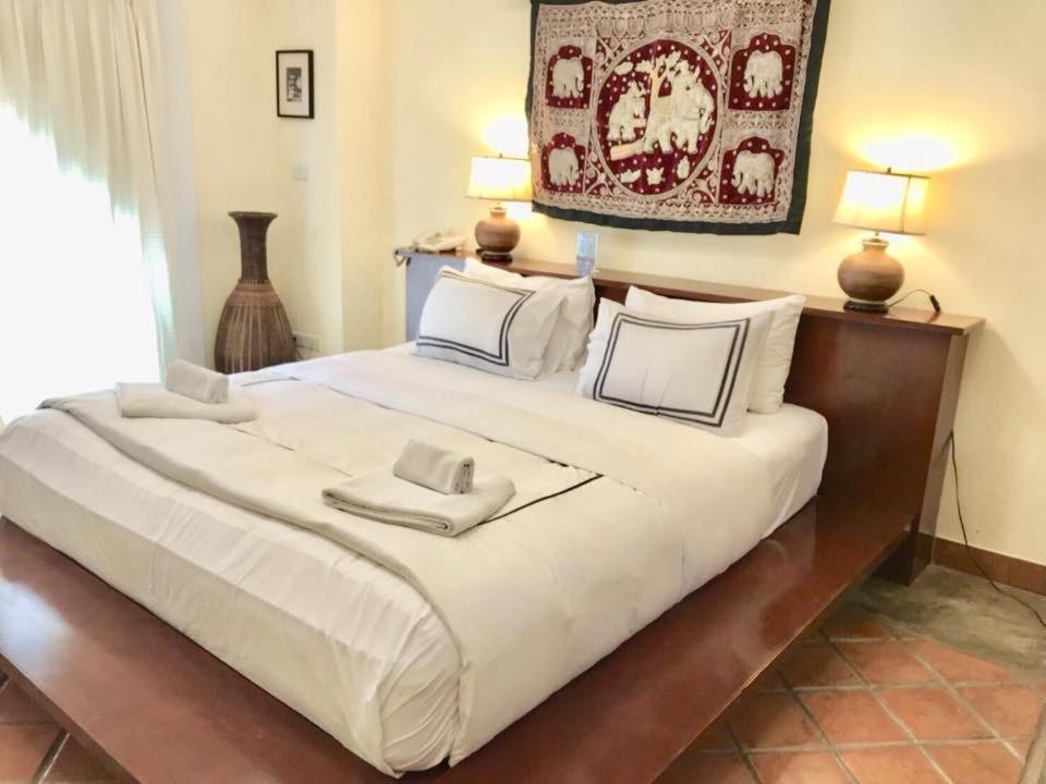 乔木提恩海滩涅磐精品套房酒店的一张带两个枕头的大白色床