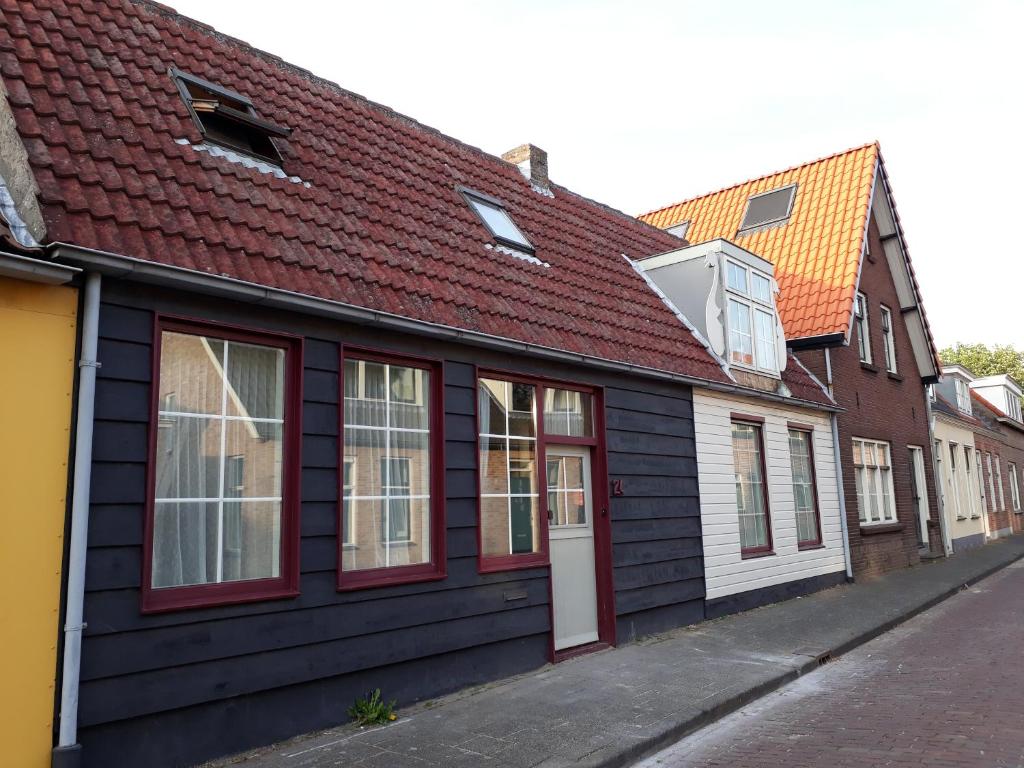 塞罗斯凯尔克Het Zwaantje的街道上一座黑色建筑,有红色屋顶