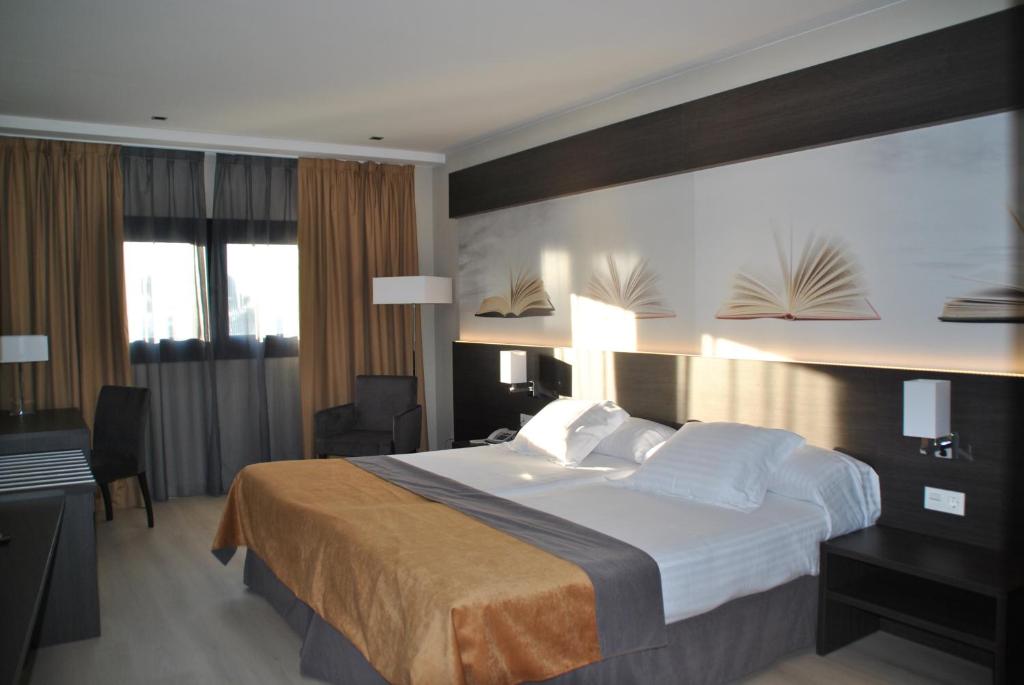 雷乌斯布瑞亚之家酒店的酒店客房设有一张大床和一张书桌。