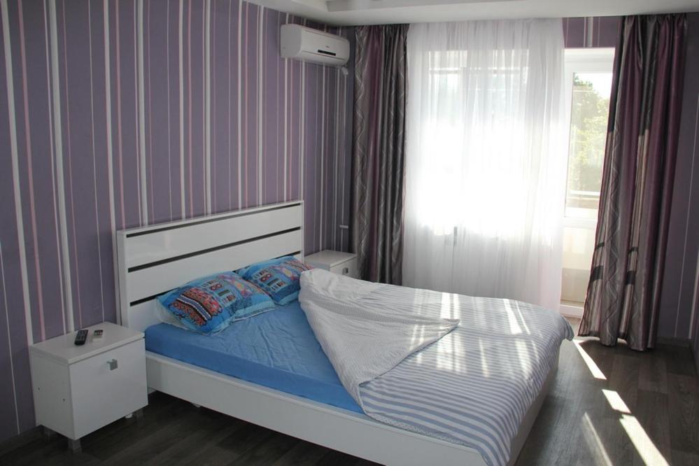 哈尔科夫Современная 1-комнатная квартира的一间卧室配有一张带蓝色床单的床和一扇窗户。