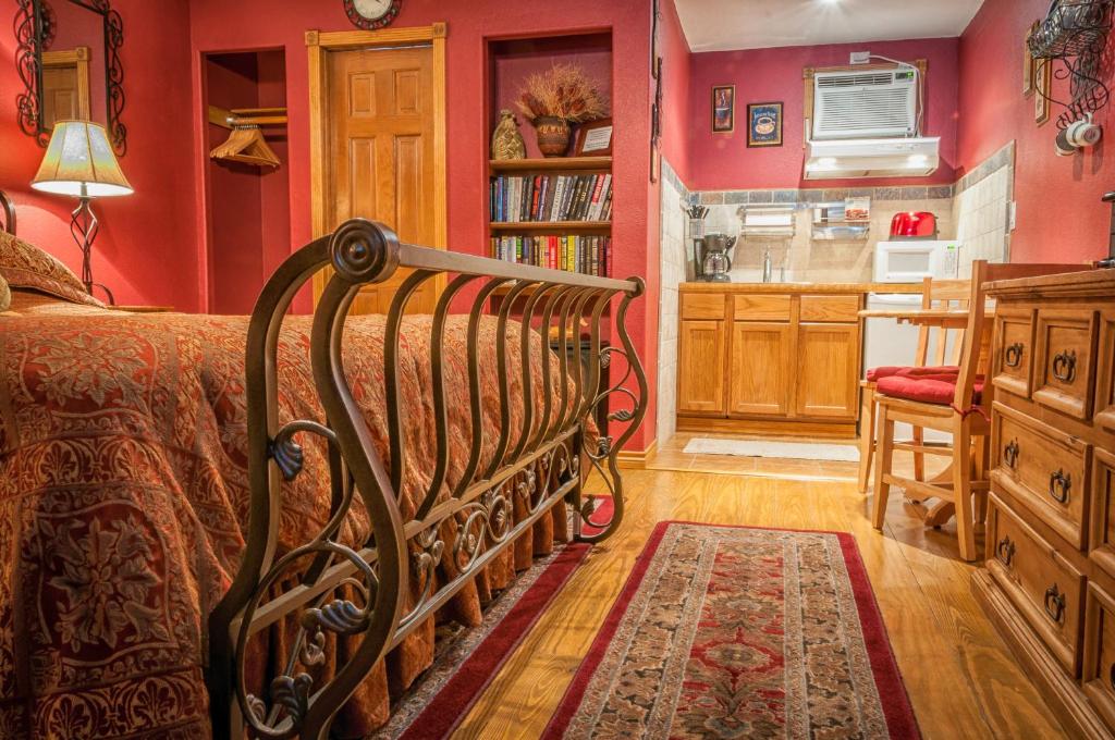 峡谷湖Holiday Lodge on Canyon Lake的一间带红色墙壁和一张床的卧室以及一间厨房