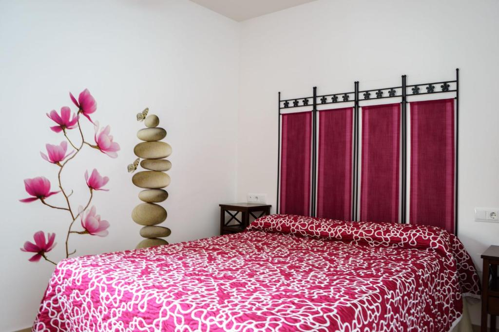 巴埃萨"Ventana del Guadalquivir "的一间卧室配有一张红色床罩的床