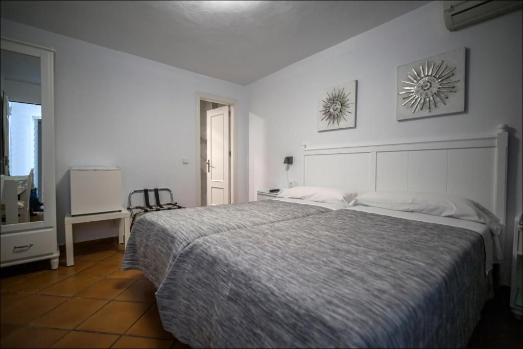 马贝拉Hostal San Ramón的白色卧室配有一张大床和一张书桌