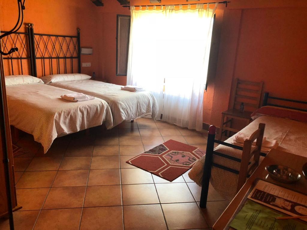 Casillas de BerlangaHotel CTR San Baudelio的卧室配有两张床、窗户和瓷砖地板。