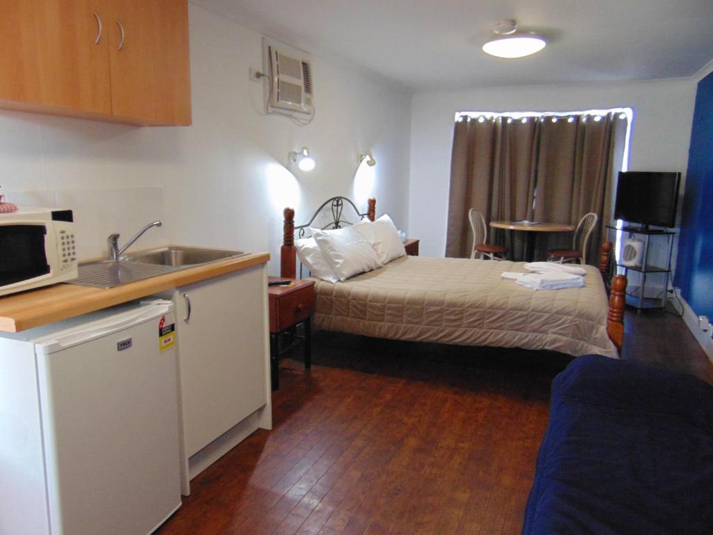弗里曼特弗里曼特尔村酒店的一间卧室配有一张床,厨房配有水槽