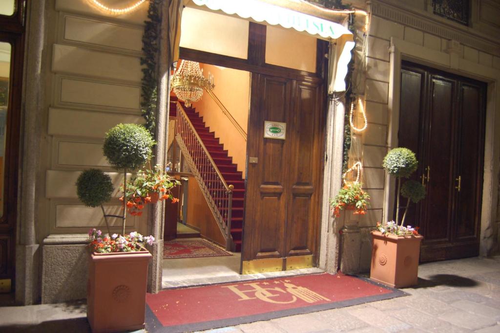 都灵查尔斯酒店的房屋的前门,有楼梯和盆栽植物