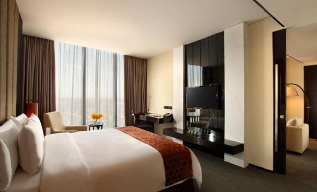 三宝垄PO Hotel Semarang的酒店客房设有一张大床和一张书桌。