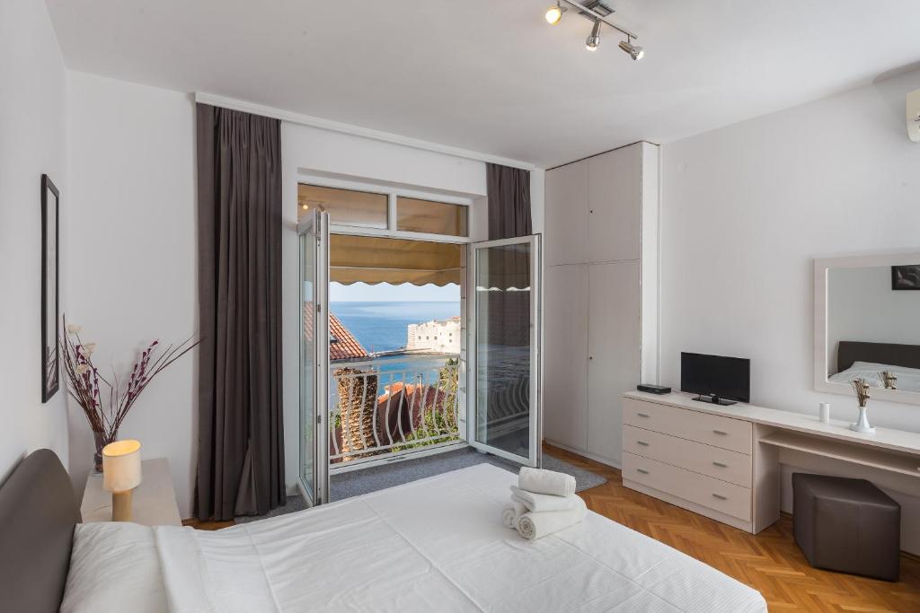 杜布罗夫尼克Apartments Green Scenic的一间卧室设有一张床和一个美景窗户。