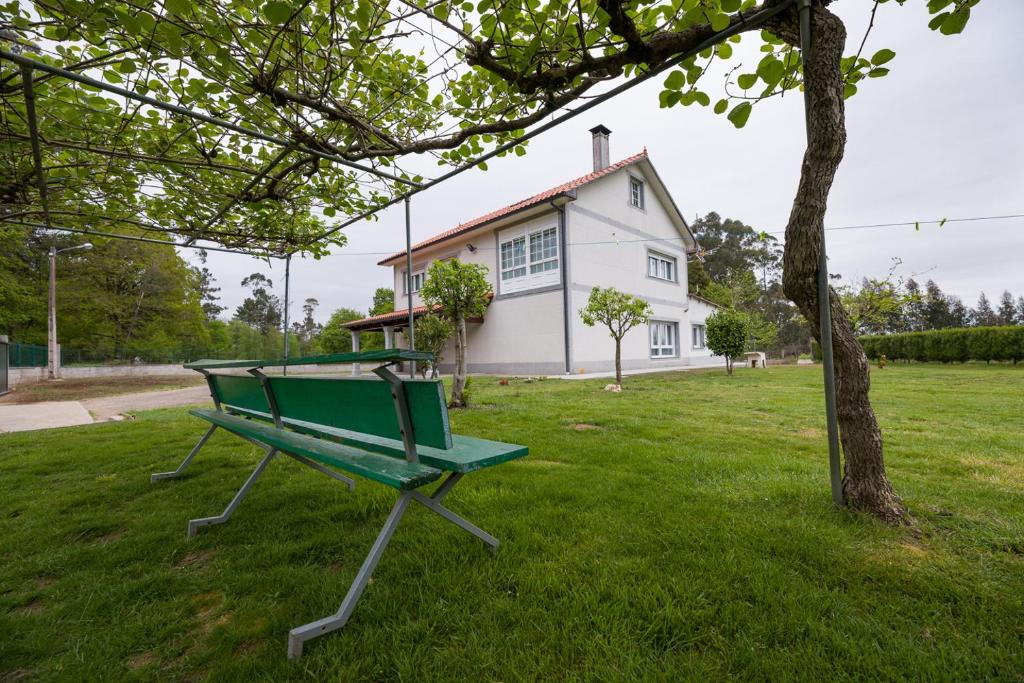 阿尔苏阿A Chousa的坐在房子前面的草上的一个绿色长凳