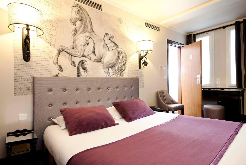 巴黎杜克丹鲁酒店的卧室配有一张大床,墙上挂有绘画作品