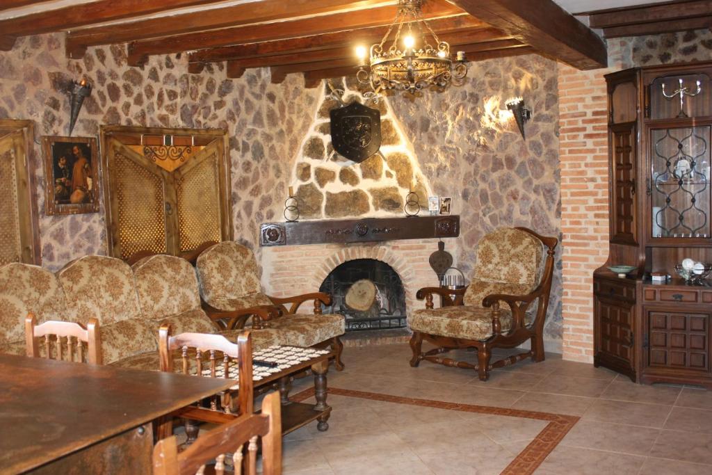 米兰达德尔卡斯塔尼亚尔Casa Rural El Palatino的客厅设有石制壁炉和椅子