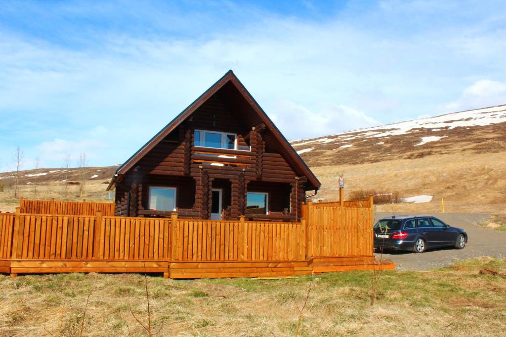 阿克雷里Akureyri Log Cottage的小木屋前方设有停车位