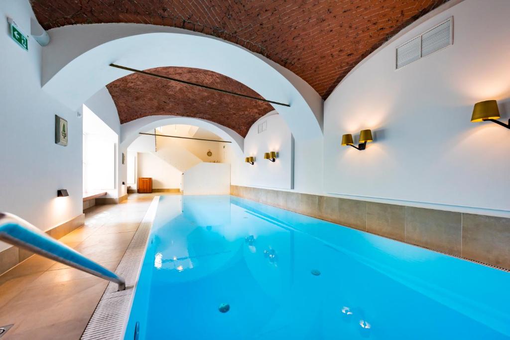 格拉茨Parkhotel Graz - Traditional Luxury的一座位于大楼内的蓝色海水室内游泳池