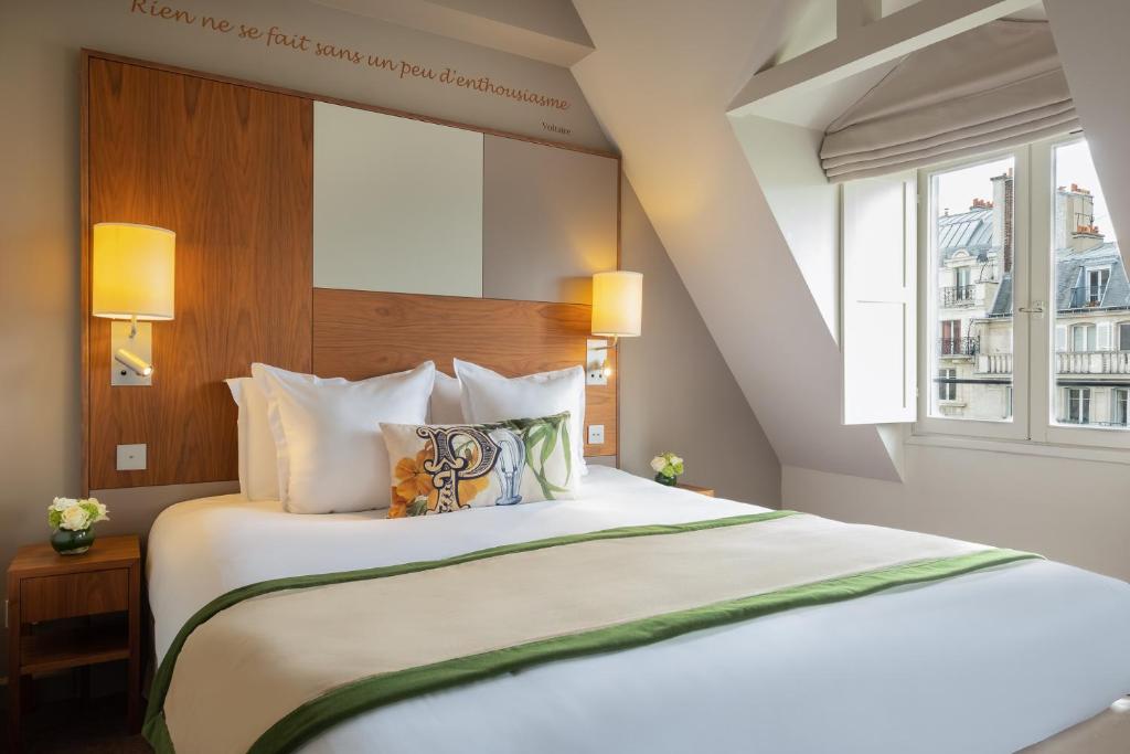 巴黎Hôtel Le Tourville by Inwood Hotels的卧室配有一张大白色床和窗户