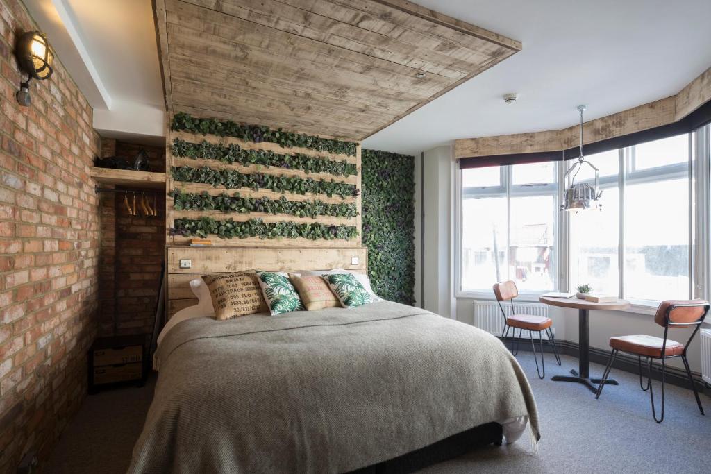 布莱顿霍夫One Broad Street的一间卧室设有一张床和砖墙