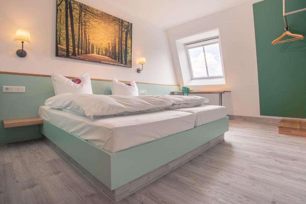 HimmelkronAuszeit Das Hotel Himmelkron的一张大床,位于带绿色墙壁的房间