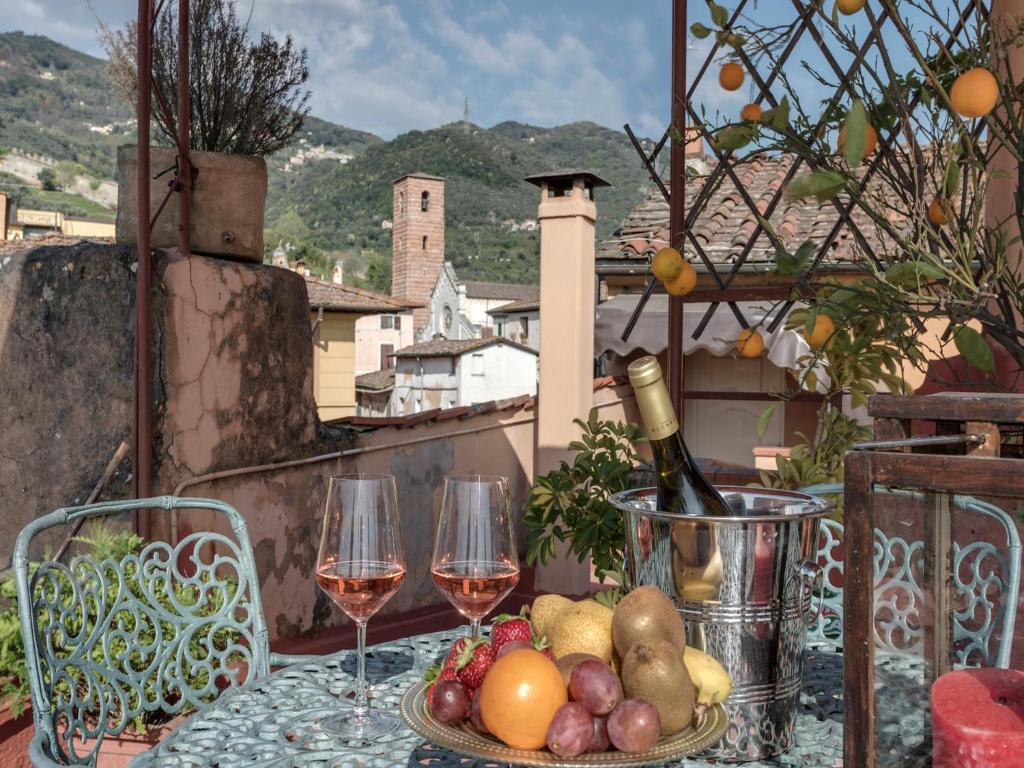 彼得拉桑塔帕拉吉酒店的阳台上的桌子上摆放着酒杯和水果