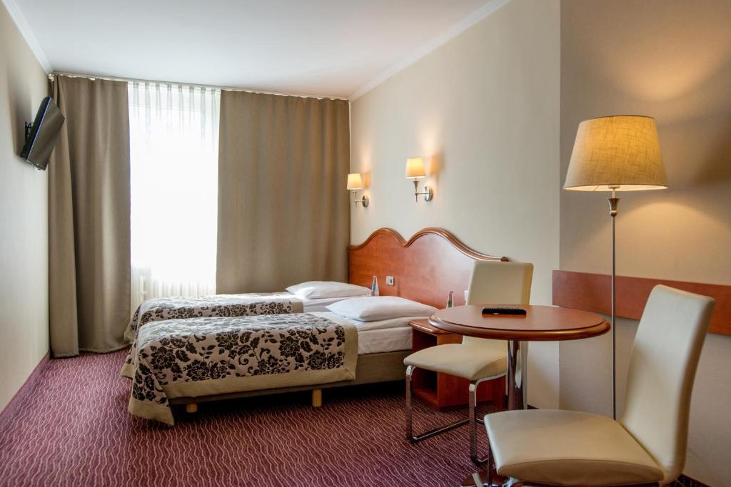 克拉科夫克拉库斯酒店的酒店客房配有一张床铺和一张桌子。
