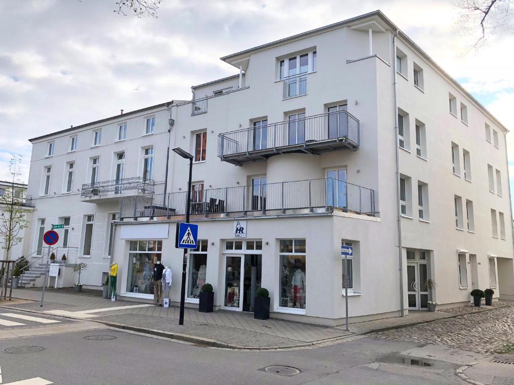 瓦尔内明德Apartment Warnemünde 10的一座白色的建筑,外面的人