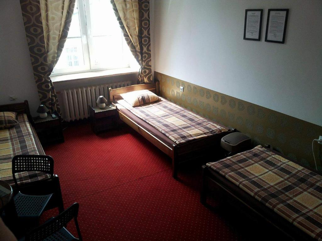 华沙马克西姆旅舍的一间卧室设有两张床和窗户。