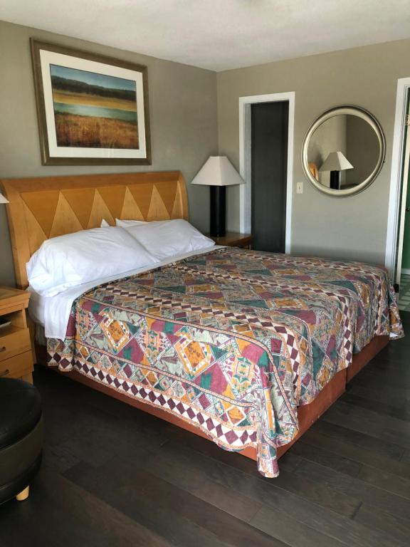 埃文Avon Motel的一间卧室配有一张大床和五颜六色的被子