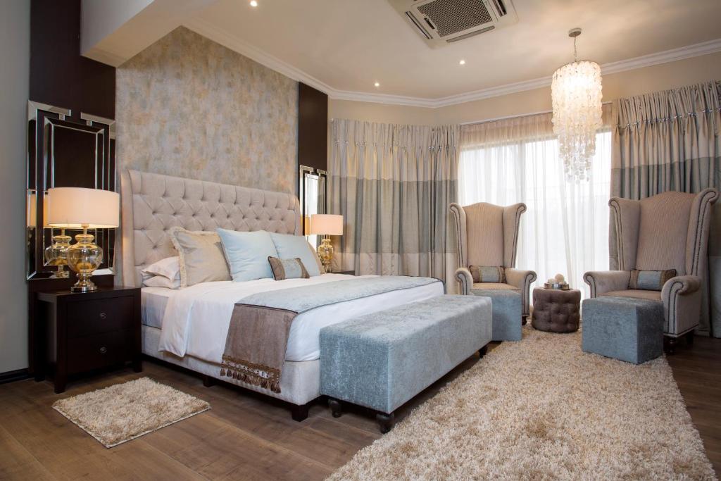阿克拉蒙蒂塞洛别墅精品酒店的一间卧室配有一张大床和两把椅子
