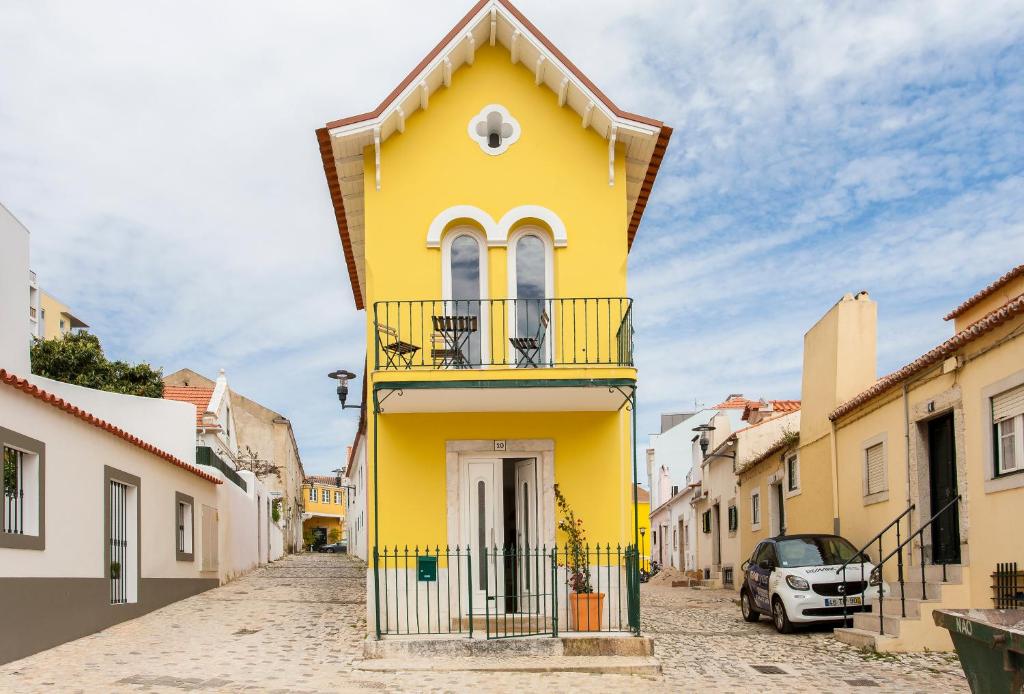 帕苏迪阿尔库什Lisbon Sea Side Chalet的街道上带阳台的黄色房屋