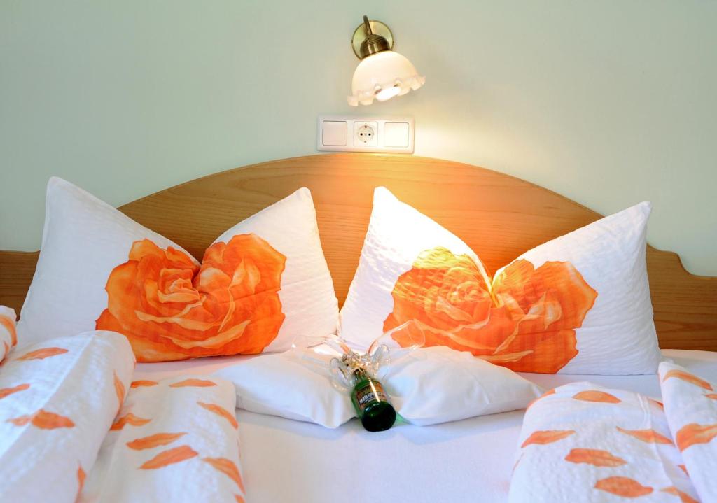 布雷根茨沃尔德地区奥Frühstückspension Rüf的一张带橙色枕头的床和一瓶