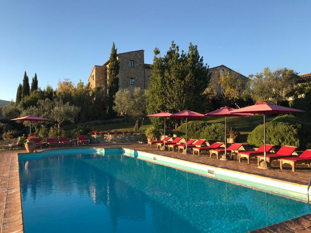 托迪特努纳迪卡诺尼卡酒店的一个带红色椅子和遮阳伞的游泳池