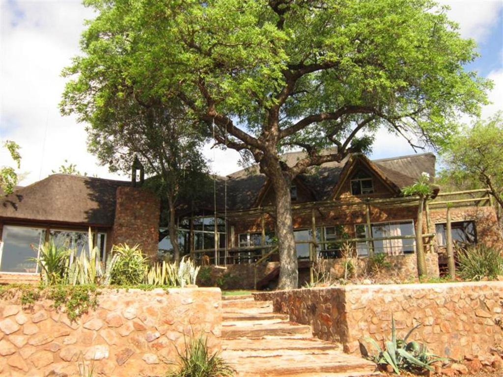 塔巴津比马鲁拉小屋宾客旅舍的一座有树和石墙的房子