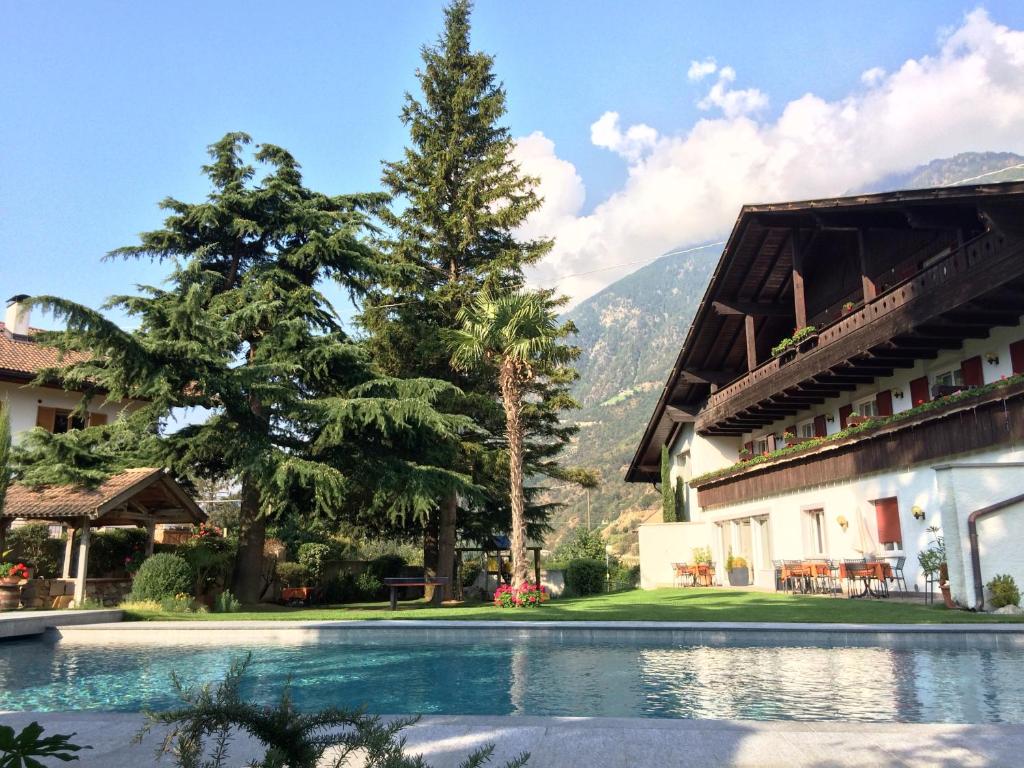 纳图尔诺Hotel Quellenhof的一座带游泳池和山脉的度假村
