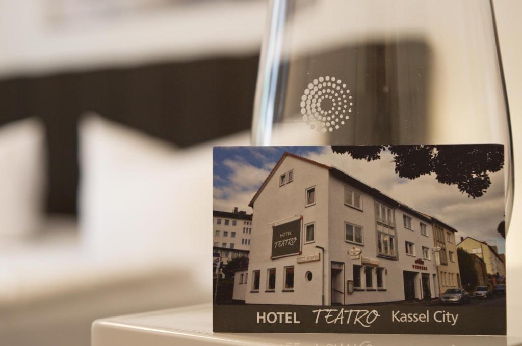 卡塞尔Hotel Teatro的一杯酒,带酒店的照片