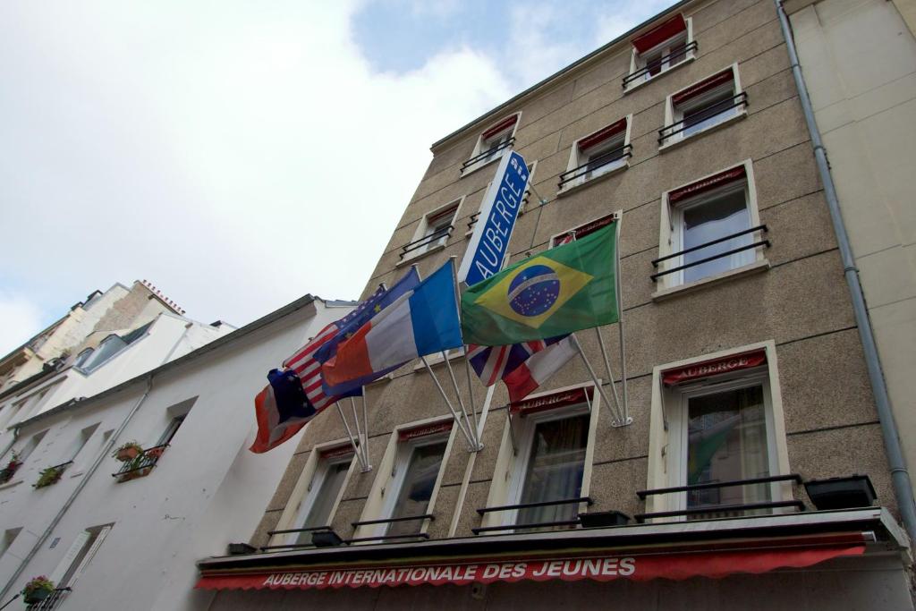 巴黎Auberge Internationale des Jeunes的建筑物一侧的两面旗帜
