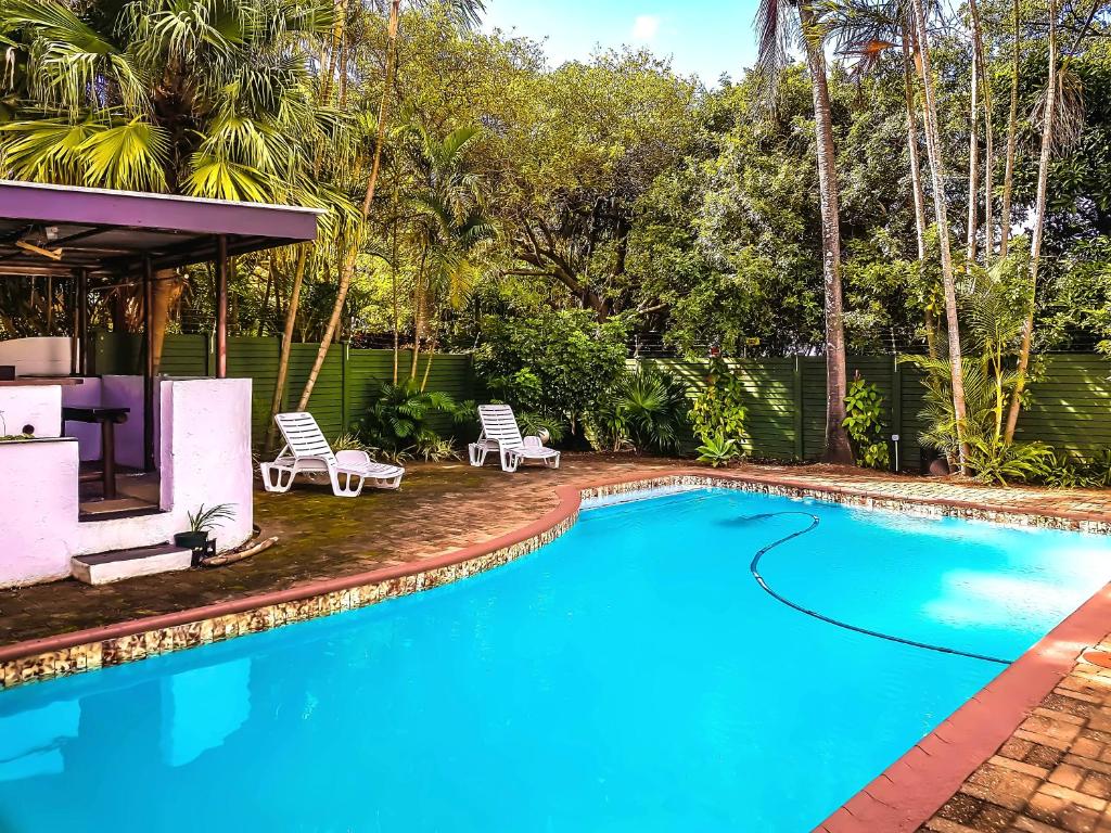 马盖特Villa Tropicana - South Africa的一个带椅子的游泳池以及一座房子