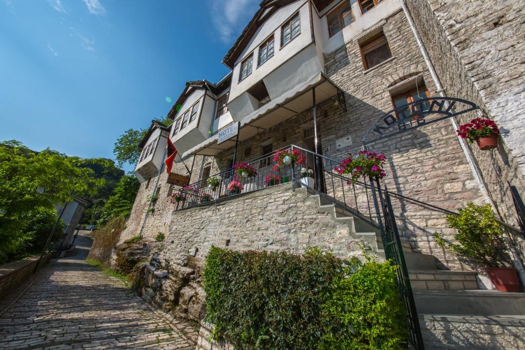 吉诺卡斯特卡托里住宿加早餐酒店的一座石头建筑,在阳台和楼梯上种满了鲜花