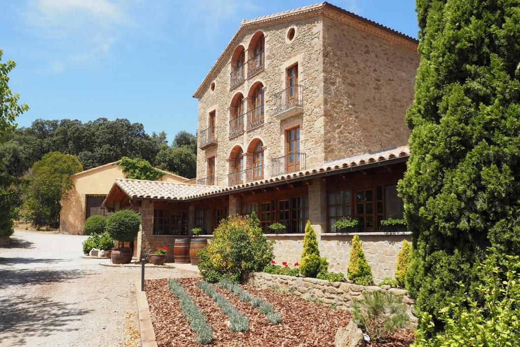 L'Espunyola卡尔玛佐拉酒店的一座大型砖砌建筑,前面设有花园