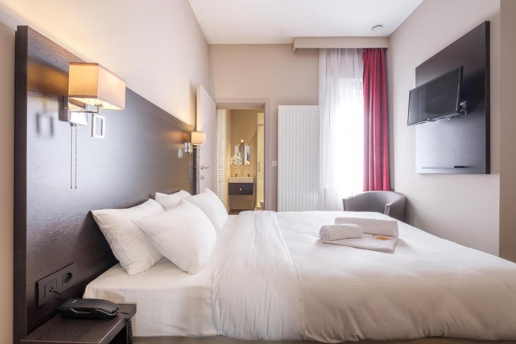 布鲁塞尔Best Budget Rooms的一间酒店客房,配有一张白色的床,上面有一本书