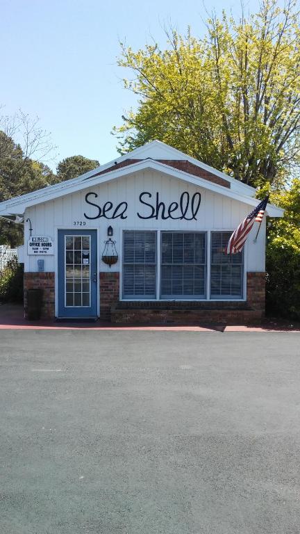 钦科蒂格Sea Shell Motel的前面有美国国旗的海 ⁇ 