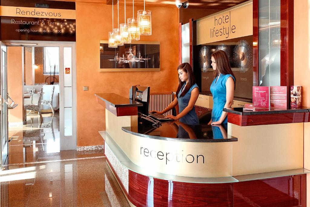 布拉格萨帕酒店的两个女人站在商店的接待台