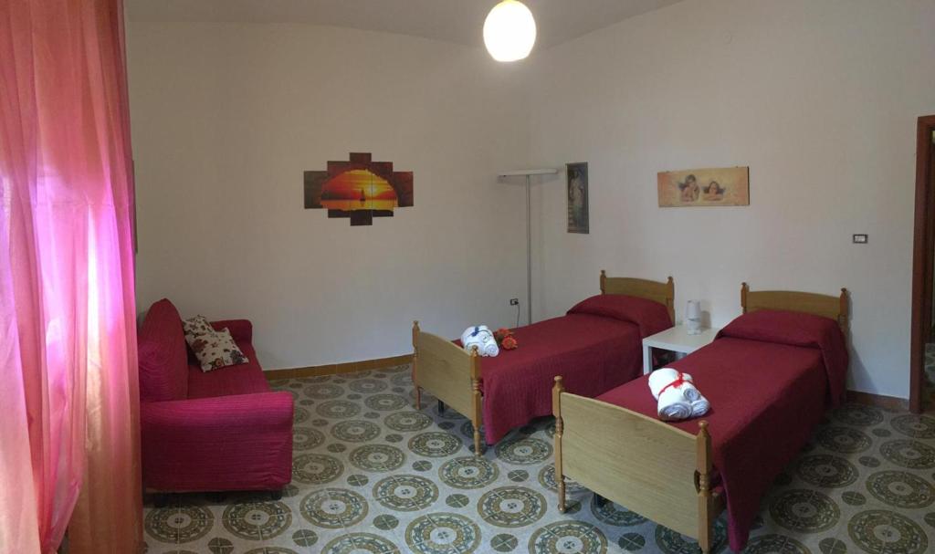 拉卡莱Casa "Salentus"的一间设有两张床、一张沙发和一把椅子的房间