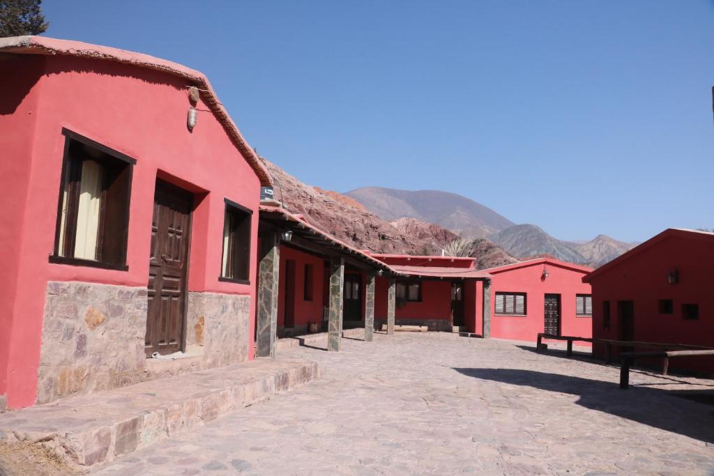 普尔马马尔卡Hostal Paseo de los Colorados的山底下一排红色的建筑