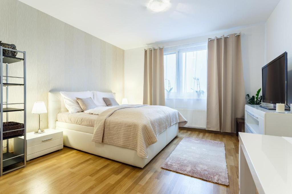 俄斯特拉发Golden Apartments Rezidence Nová Karolina的一间白色卧室,配有床和电视